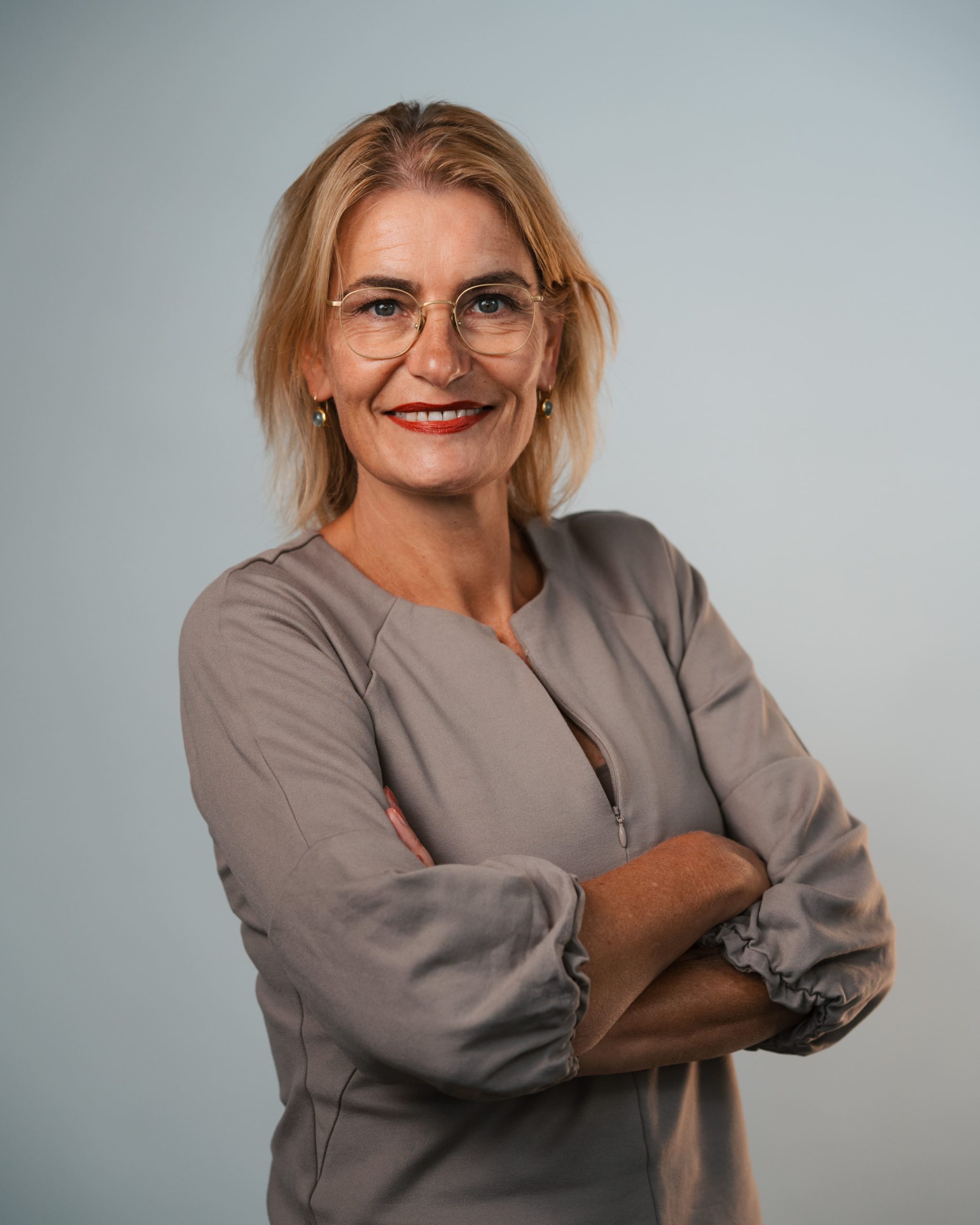 Vrouw met bril en beige blouse, eigenaar Qudo Werkt